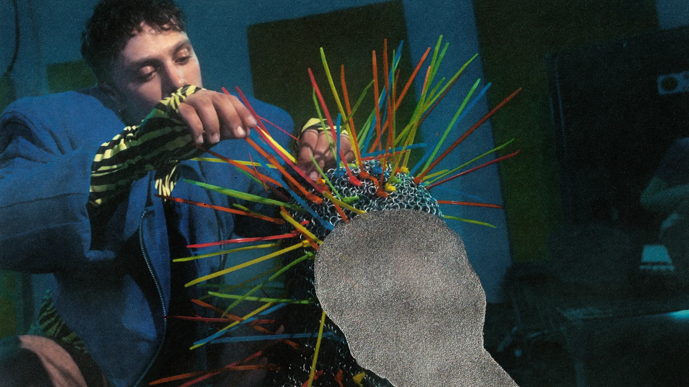Renan making the spiked helmet from colored zip ties and chainmail
